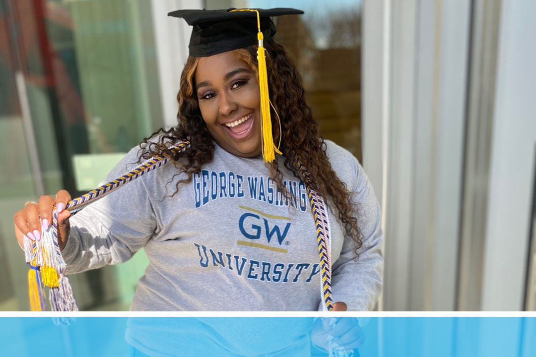 graduate poses in cap with party streamers